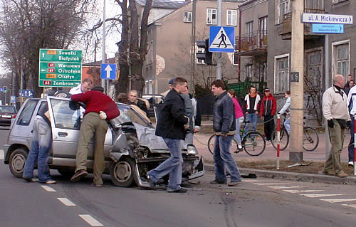 uczestnicy wypadku i obserwatorzy pomagają wydostać się z rozbitego samochodu