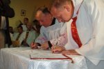 Foto: Podpisy składają wikariusz biskupi ks. Jan Sołowianiuk i ks. proboszcz Andrzej Popielski