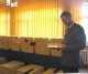 Sławomir Dąbrowski oficer prasowy łomżyńskiej policji na zarekwirowanymi przez policjantów papierosami