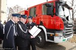 Foto: Strażacy prezentują dokument przekazania samochodu gaśniczego