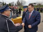 Foto: wiceminister MSWiA Jarosław Zieliński przekazuje Wojciechowi Kalinowskiemu, prezesowi OSP Stare Bożejewo akt przekazania samochodu,