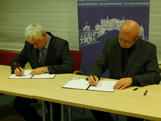 Wojewoda Bohdan Paszkowski i ks. dr Radosław Kubeł podpisują umowę na dofinansowanie projektu „Senior Alert” (fot. PUW Białystok)